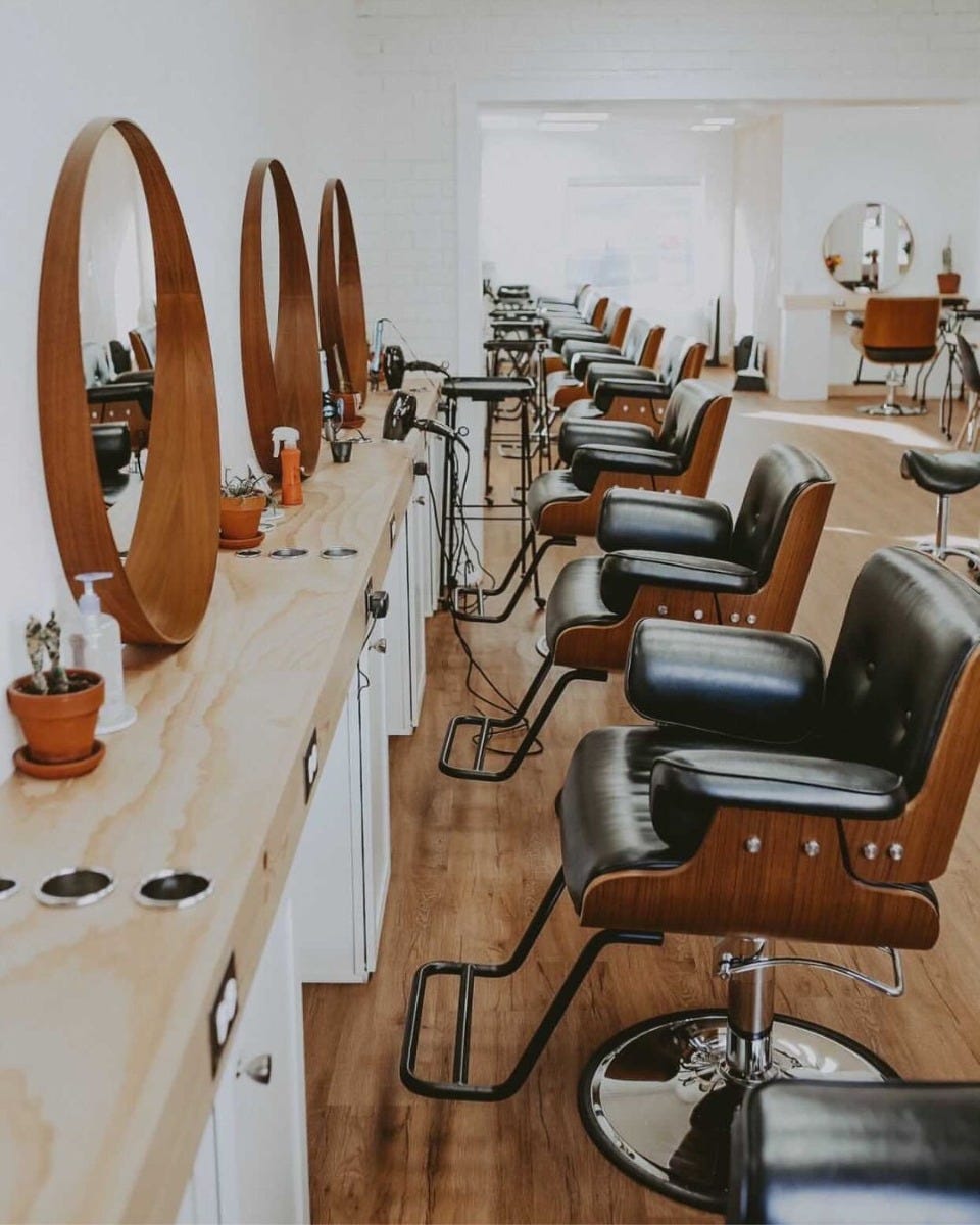 hair salon with mid century modern styling chairs and mirrors