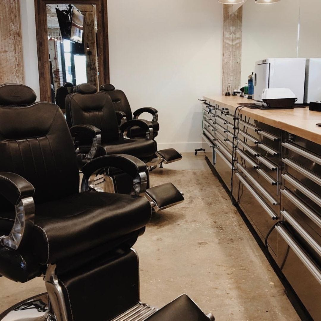 three classic barber chairs in black and chrome