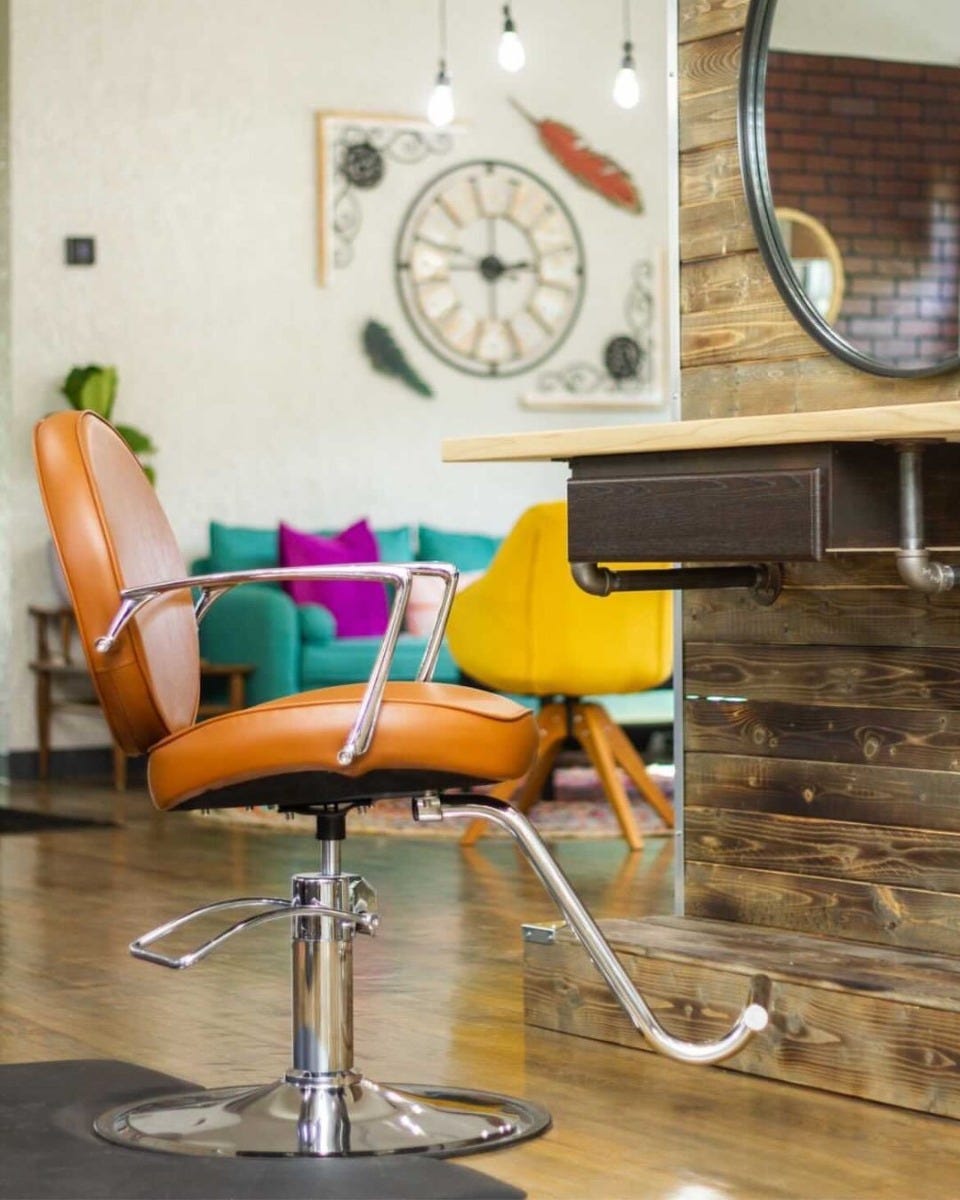 mid-century modern inspired hair salon with neutral wood tones and pops of color