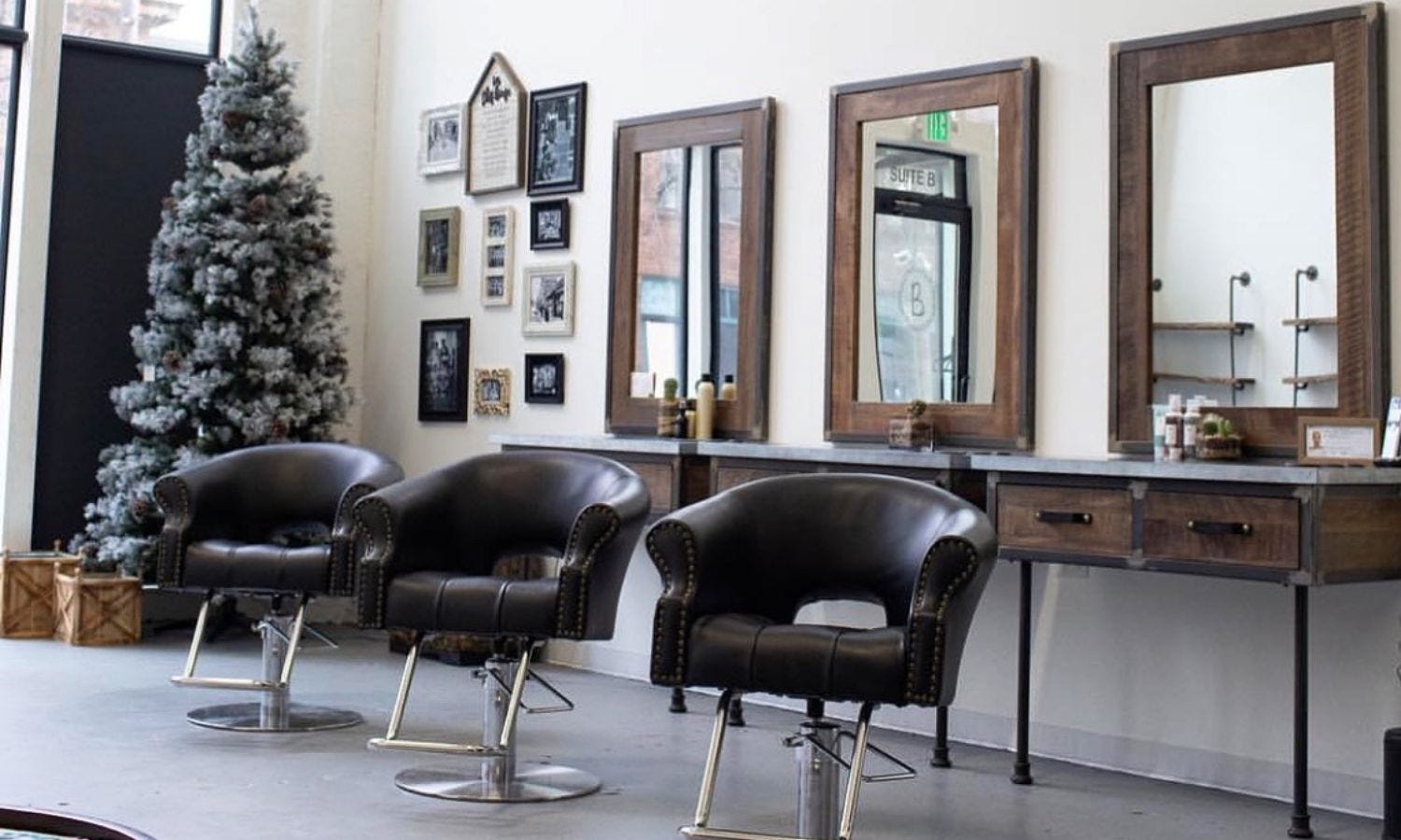 minimalist hair salon with three wall-mounted styling stations with front legs and matching mirrors