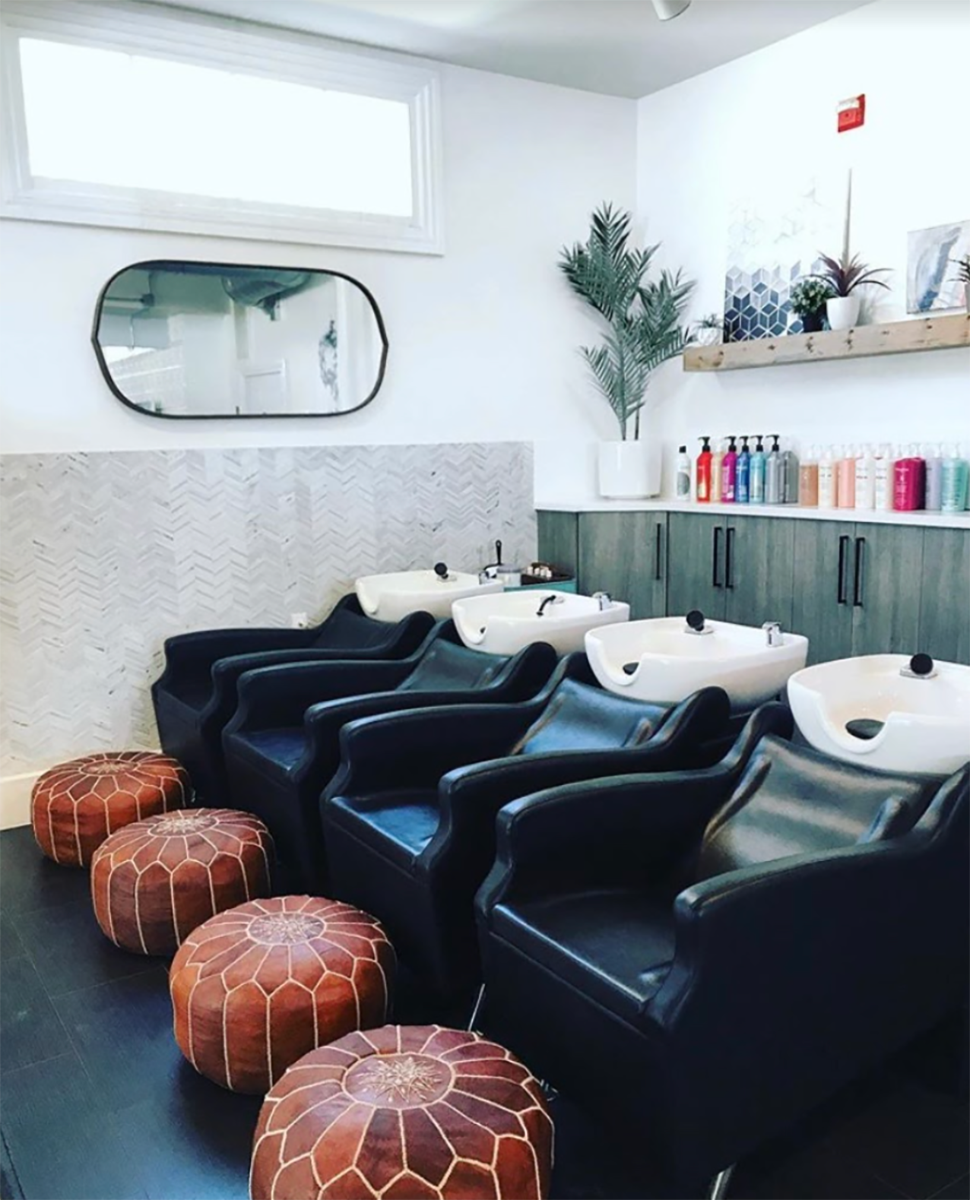 salon storage cabinets and wall-mounted shelf behind shampoo stations