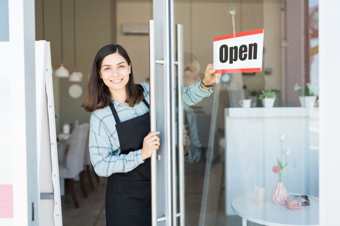 business owner turning open sign