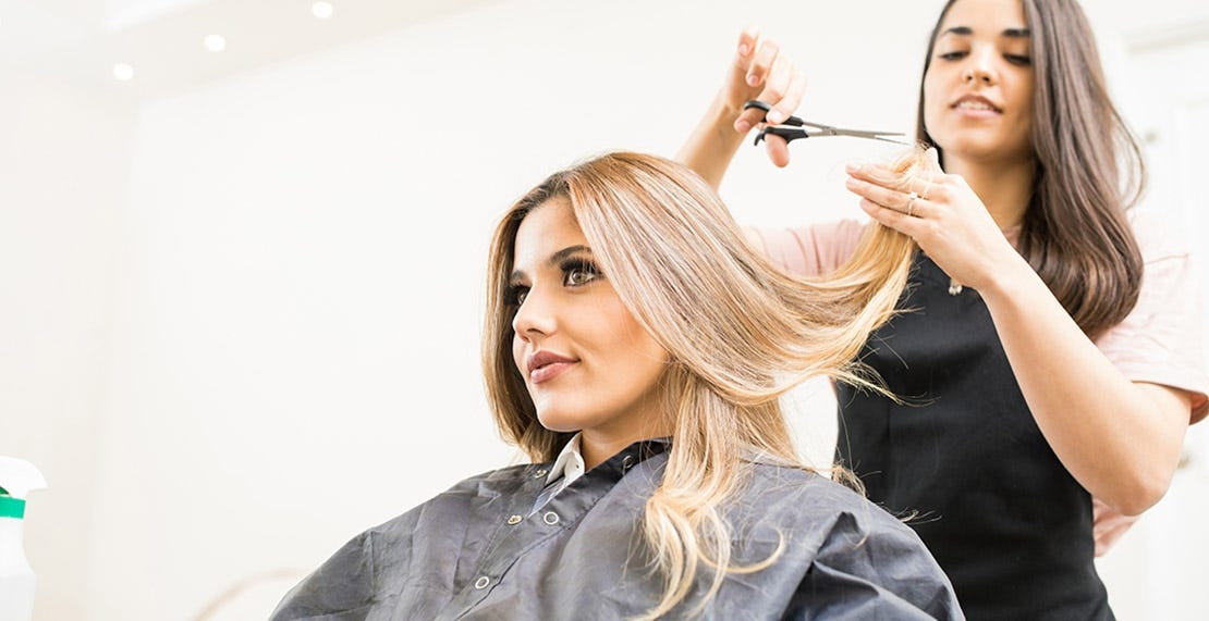 hairdresser cutting hair after salon increased prices