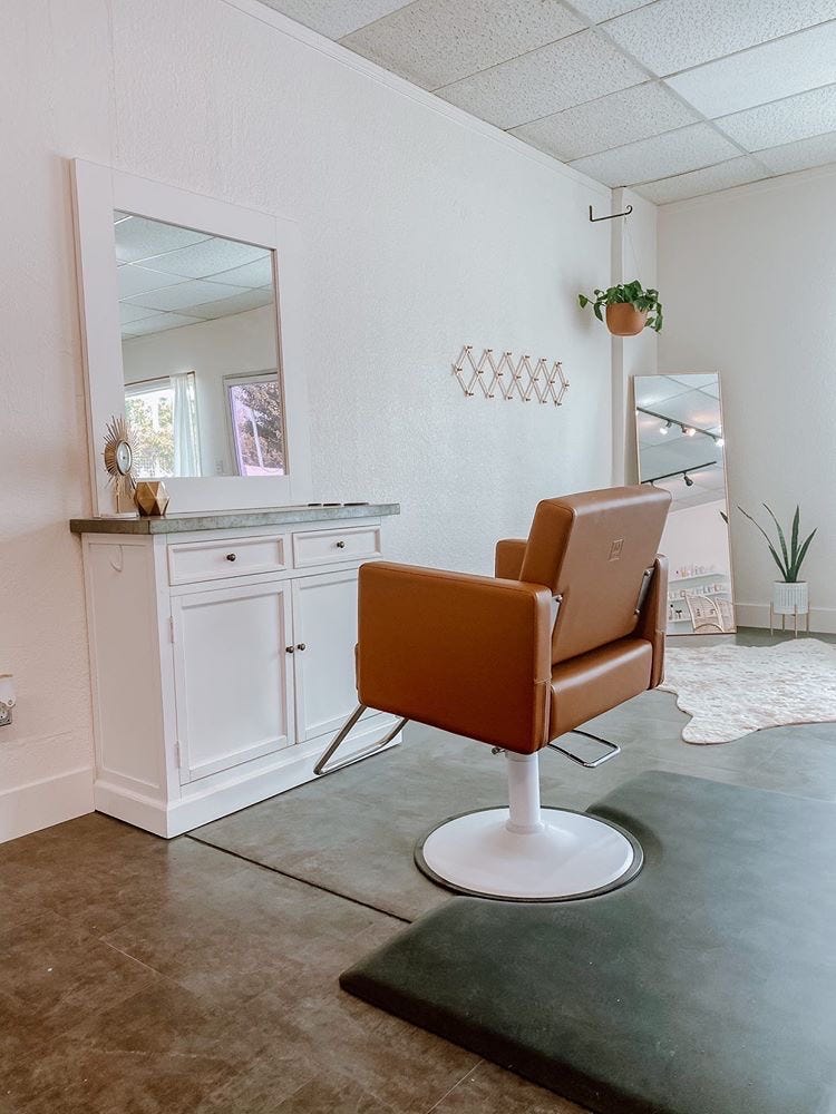 minimalist small salon suite with styling station and large mirrors