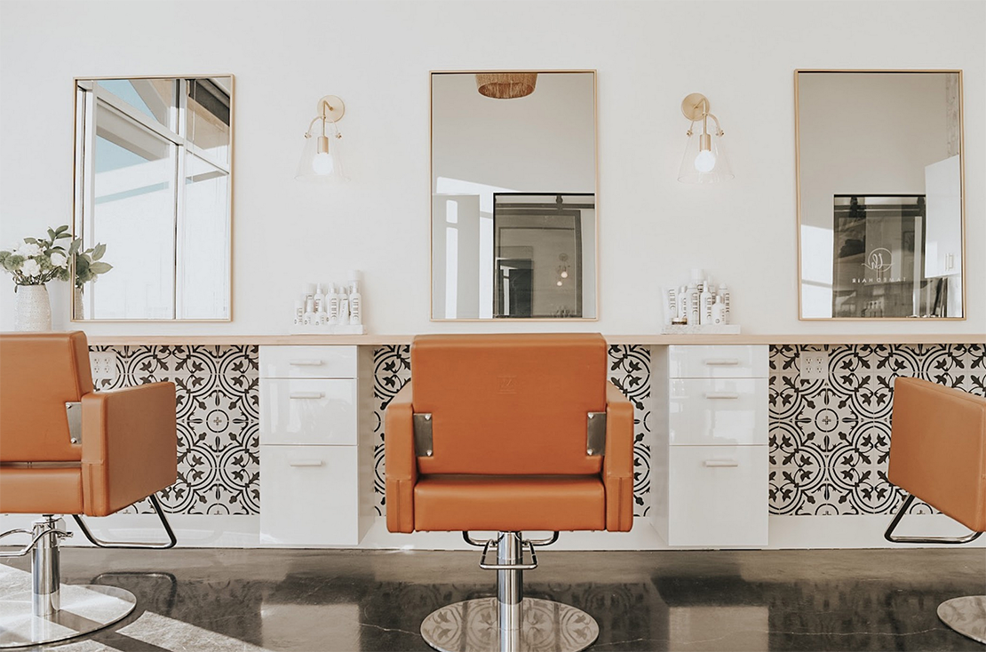 recently updated salon with orange styling chairs