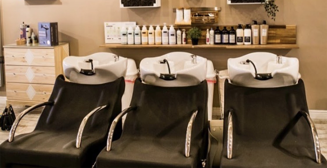 salon shampoo area with storage shelving and drawers