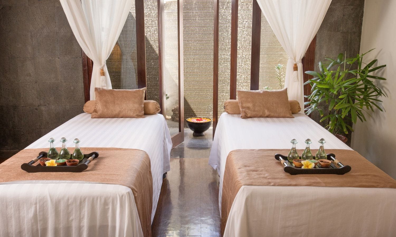 two clean and well-maintained massage tables in a spa treatment room