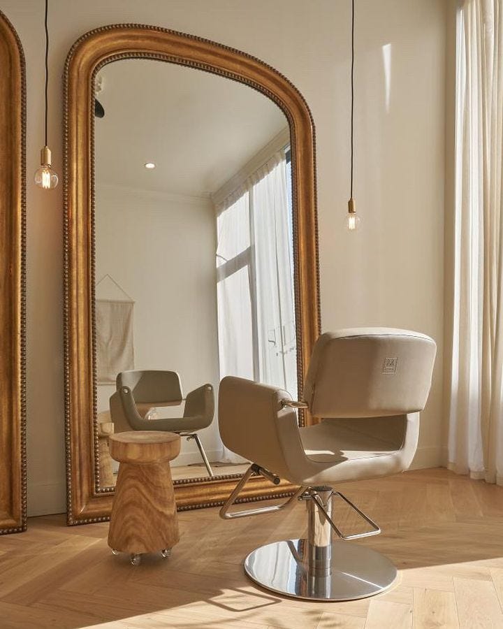 hair salon station embracing the 2025 maximalism interior design trend with oversized mirrors