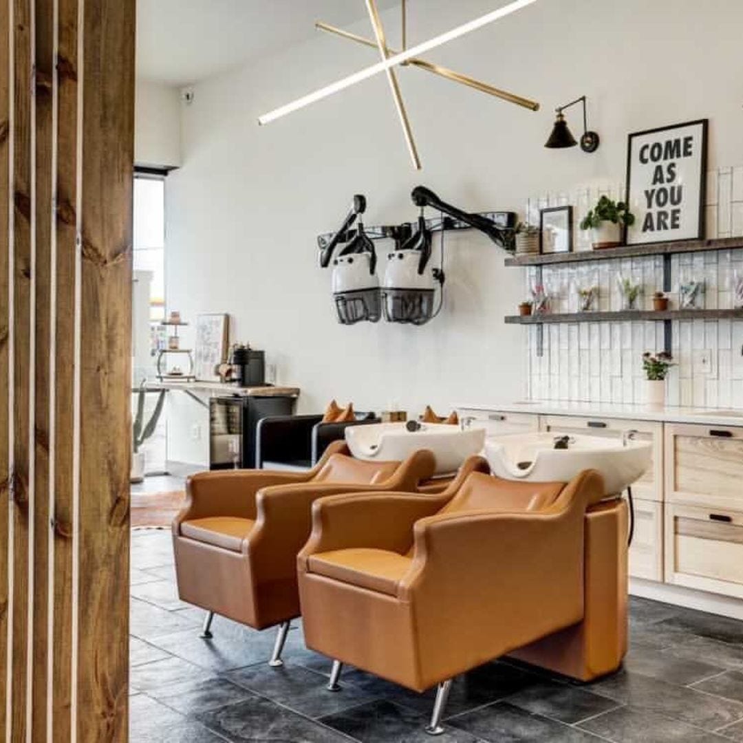 two tan shampoo backwash units with white sinks in a spacious hair salon