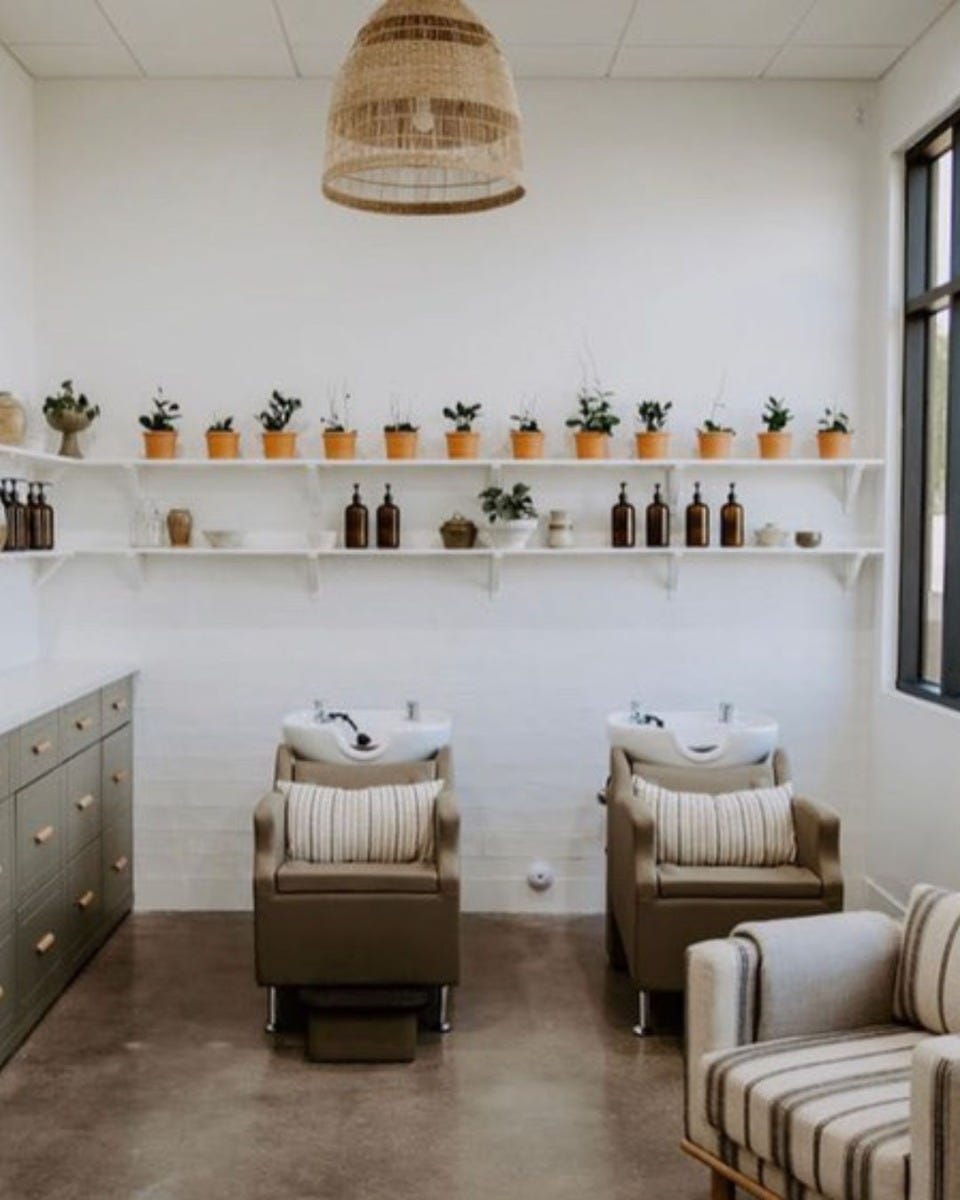 simple white wall-mounted shelves used in low-budget salon interior design