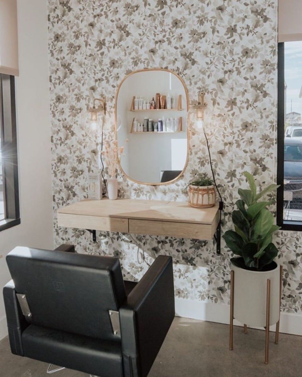 low budget beauty salon interior design with wallpaper, rose gold metal accents and potted plants