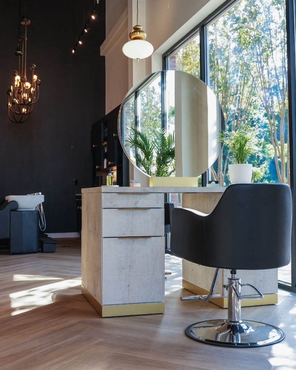 54-inch wide desk-style salon station with round mirror in an upscale hair salon