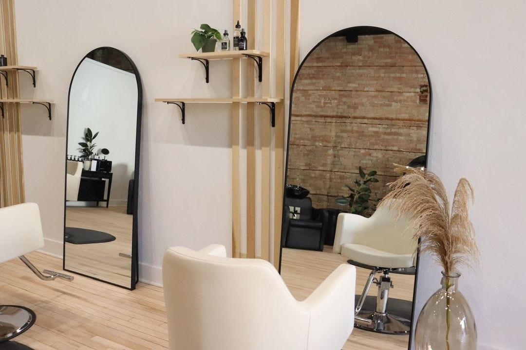 hair salon stations with large arched mirrors