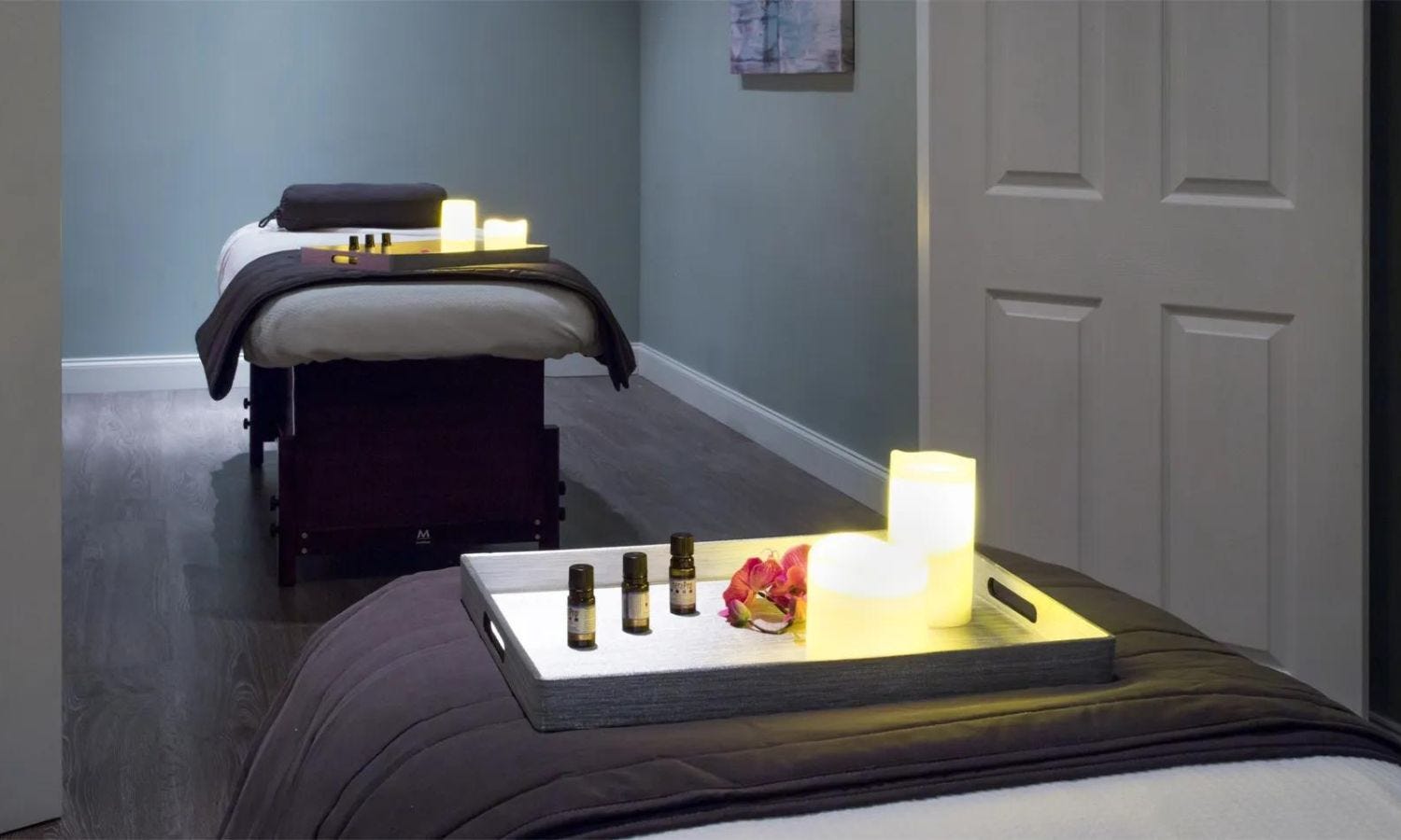 two esthetician beds in a spa treatment room set up with essential oils and flamless LED candles