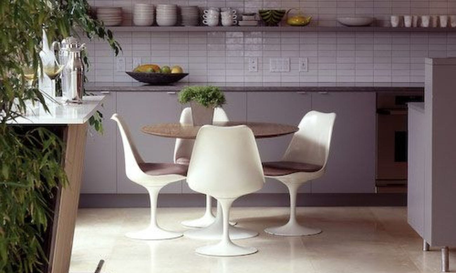 mid century modern kitchen with four white tulip chairs and round wood table