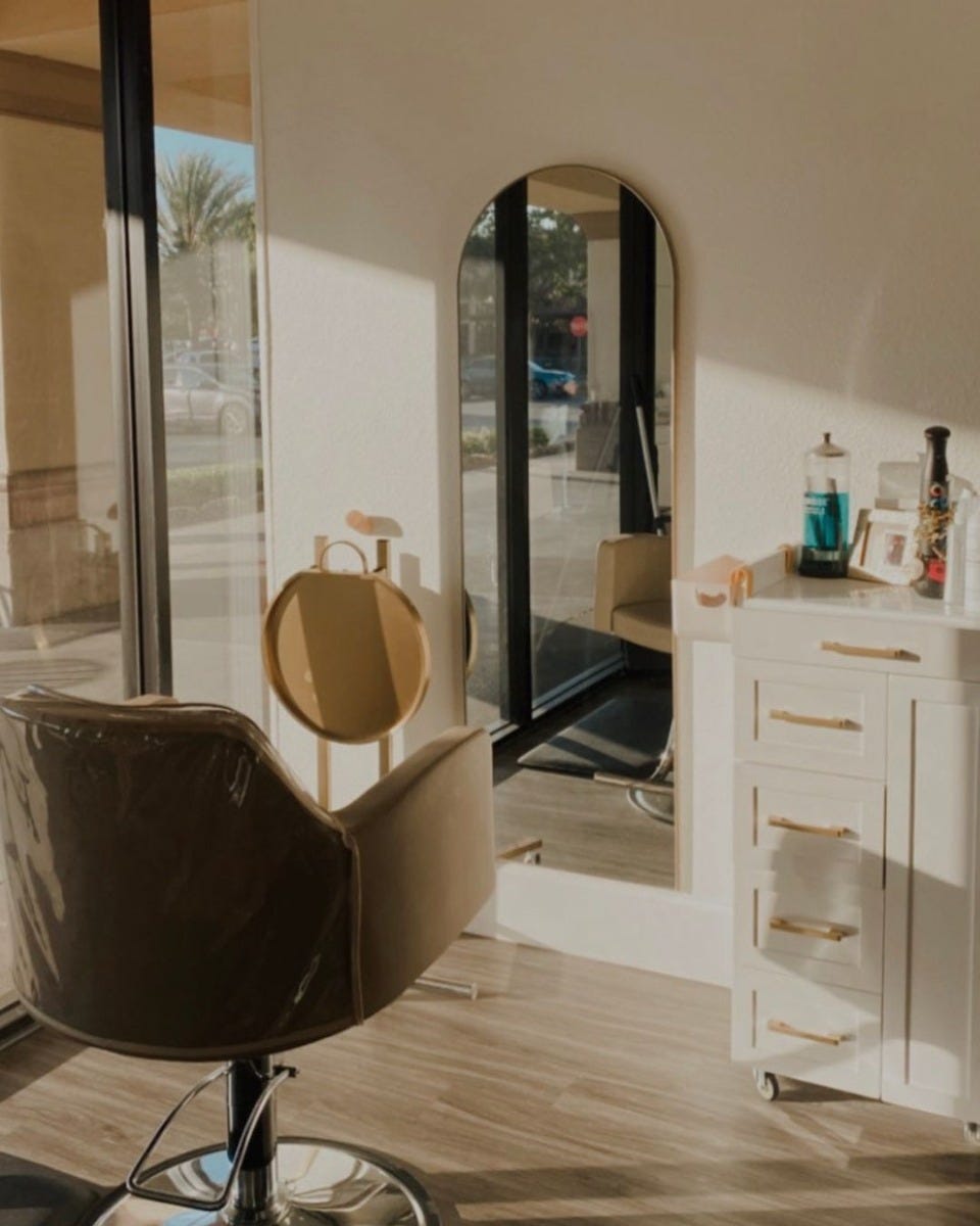 20-inch wide pedestal-style salon station with wheels and gold service tray in small salon studio