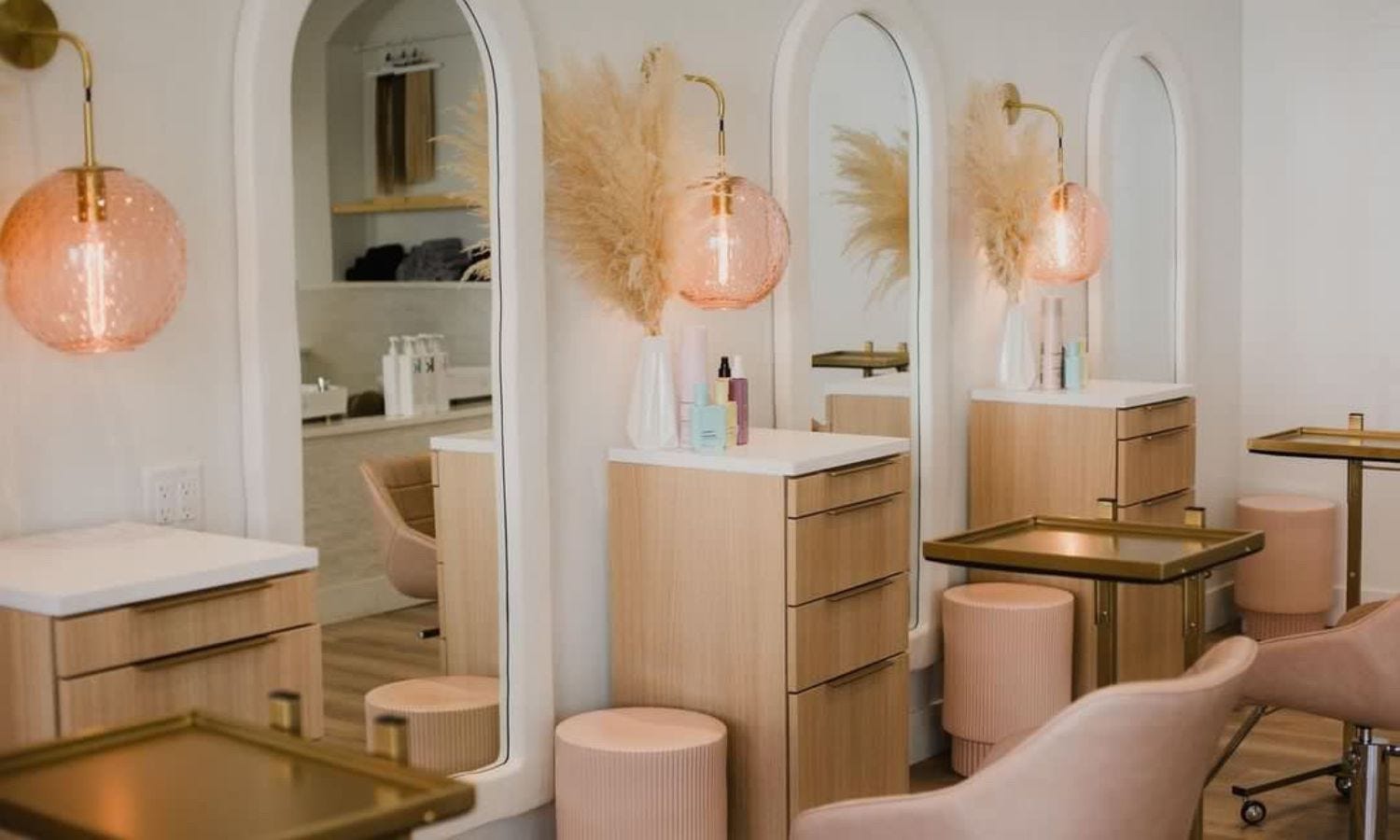 three pedestal style salon stations with four drawers in a light woodgrain color with white countertop