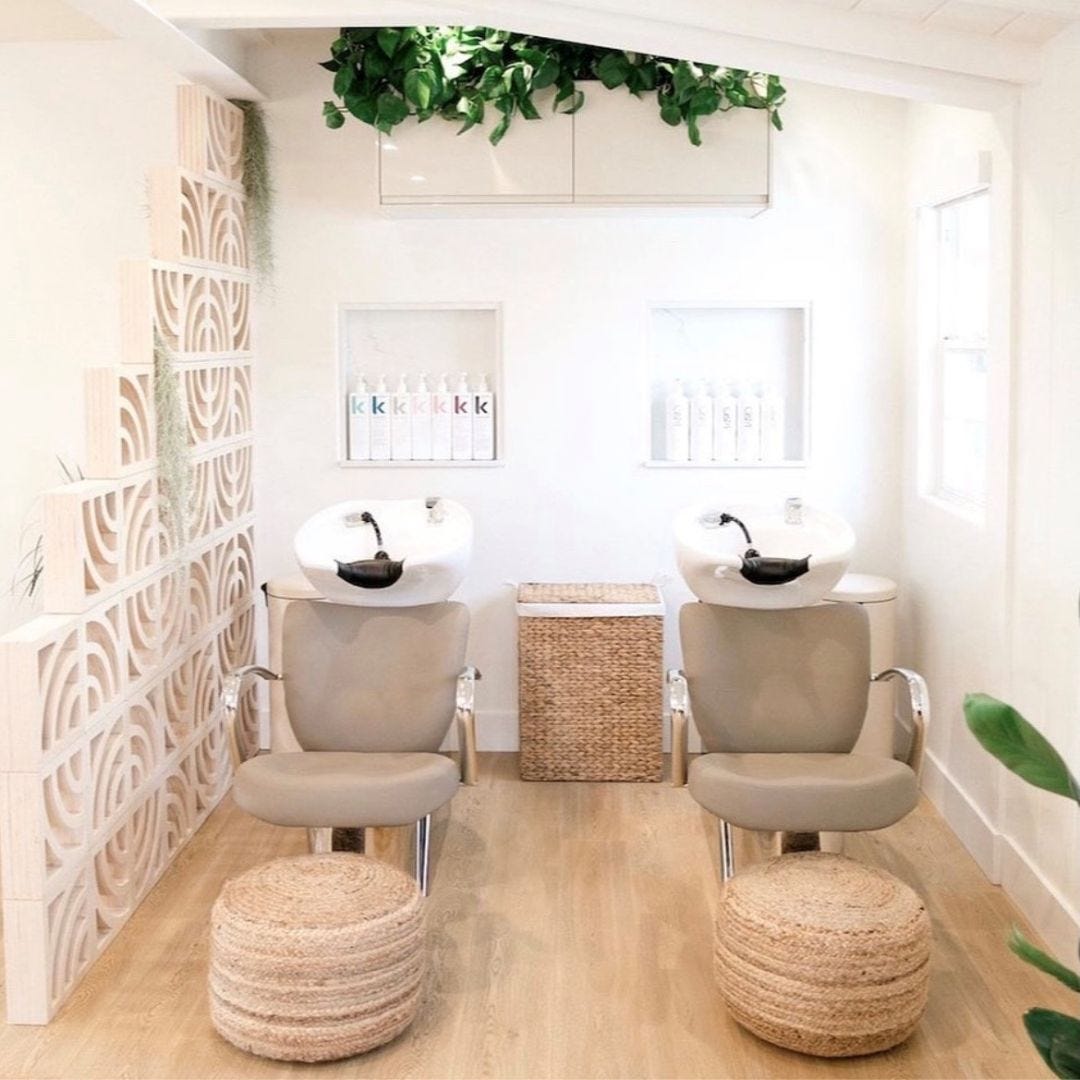 two stainless steel shampoo backwash units in a mimimalist hair salon