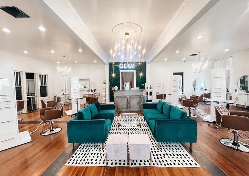 luxurious salon reception area with chandelier, sofas, tables and reception desk