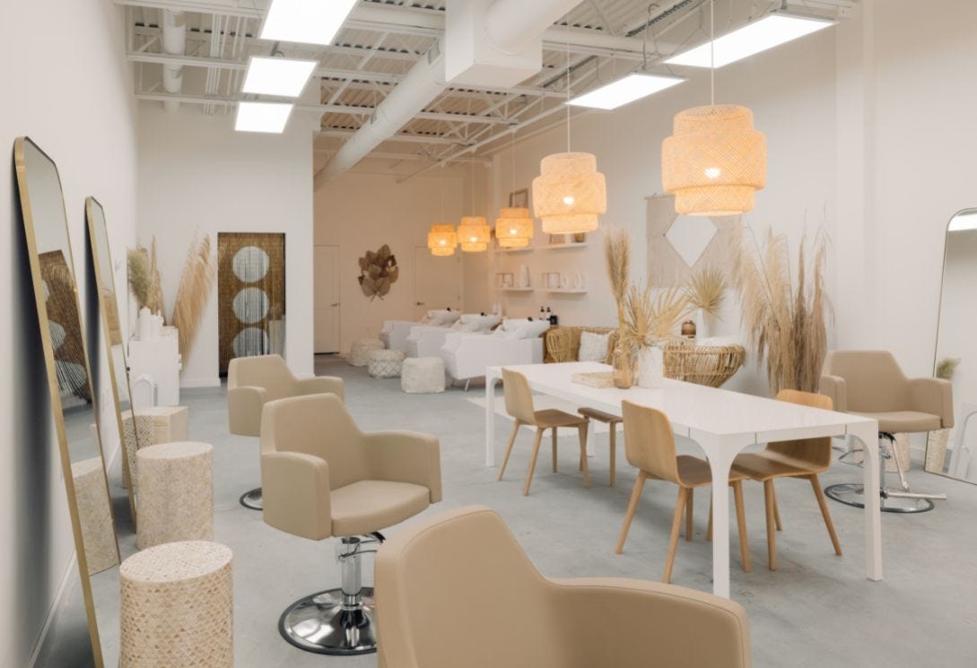 salon interior that creates a relaxing experience for guests with soft lighting, a cohesive color scheme and a layout that promotes ease of movement