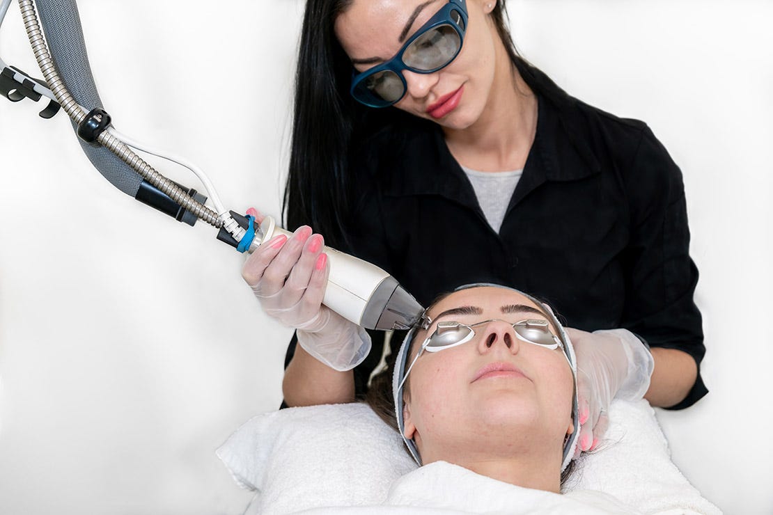 nurse practitioner providing facial treatment to a client in a new medical spa on opening day