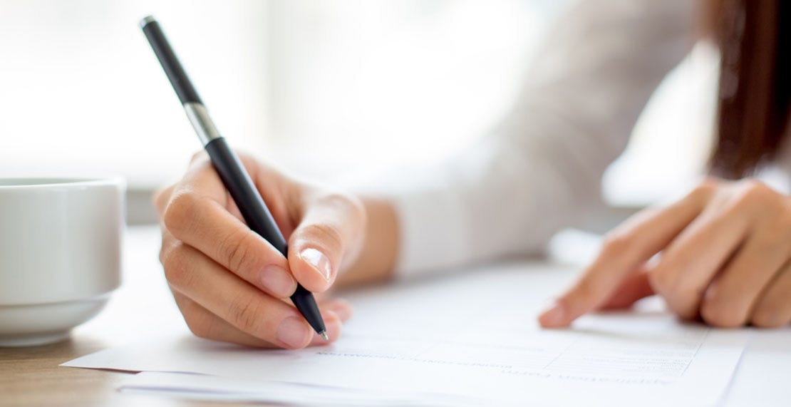 businesswoman writing on a paper