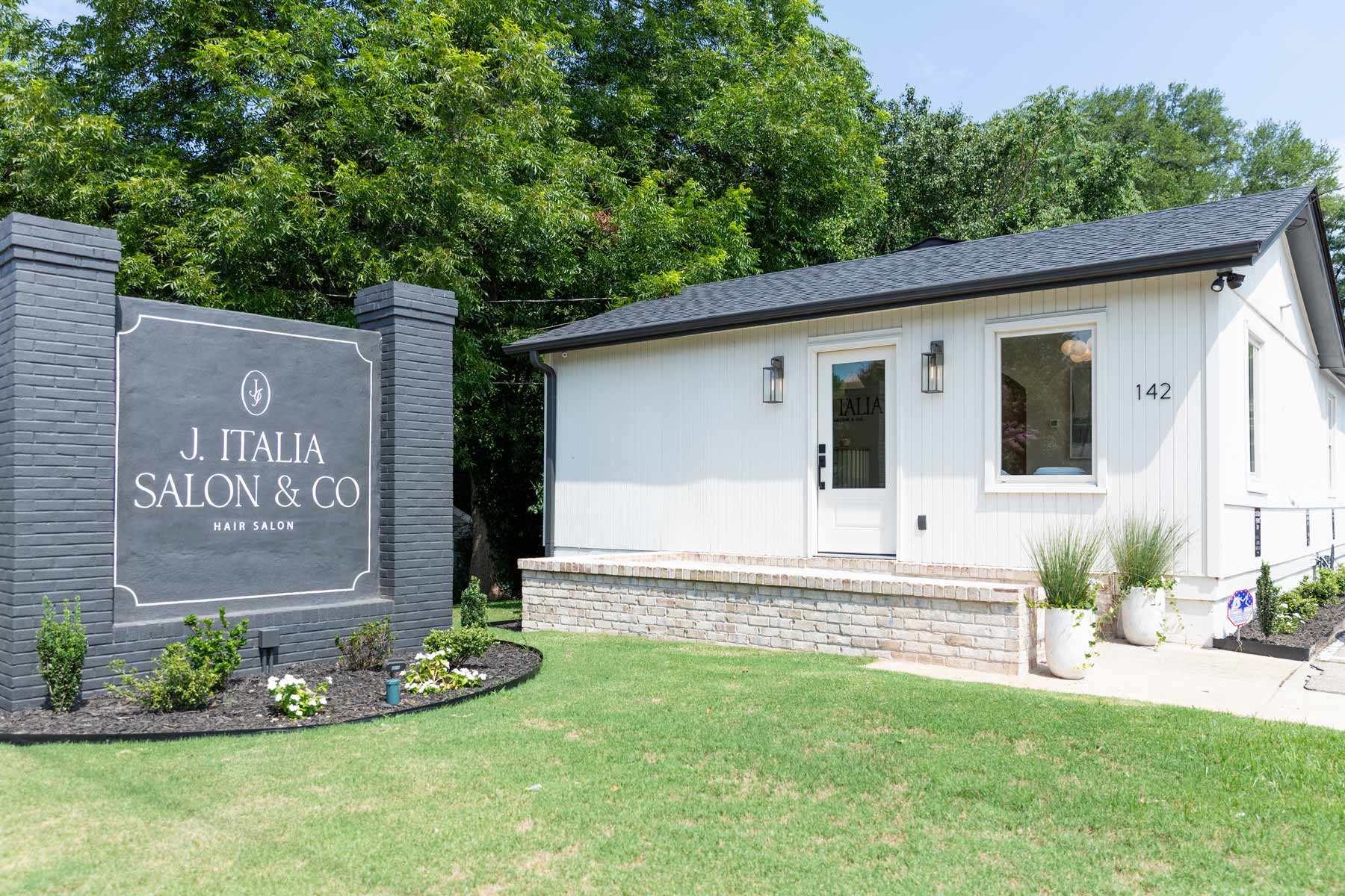 J. Italia Salon exterior view of hair salon with large stone sign in front yard