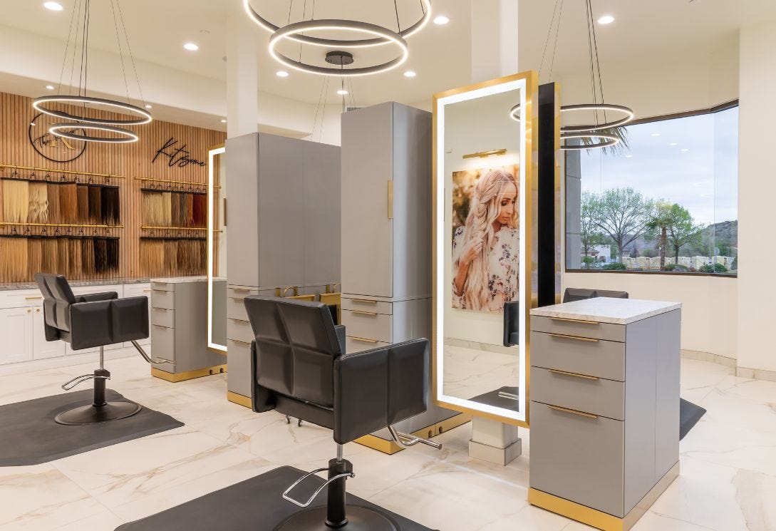 hair salon with natural light and diffuse LED lighting with large mirrors and a variety of colored hair extensions on display