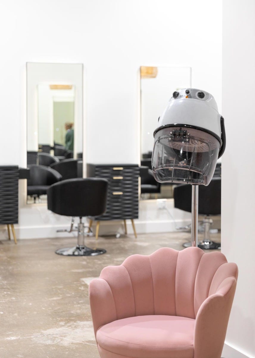 Radiant Salon & Boutique hair drying hood and chair with styling stations in the background