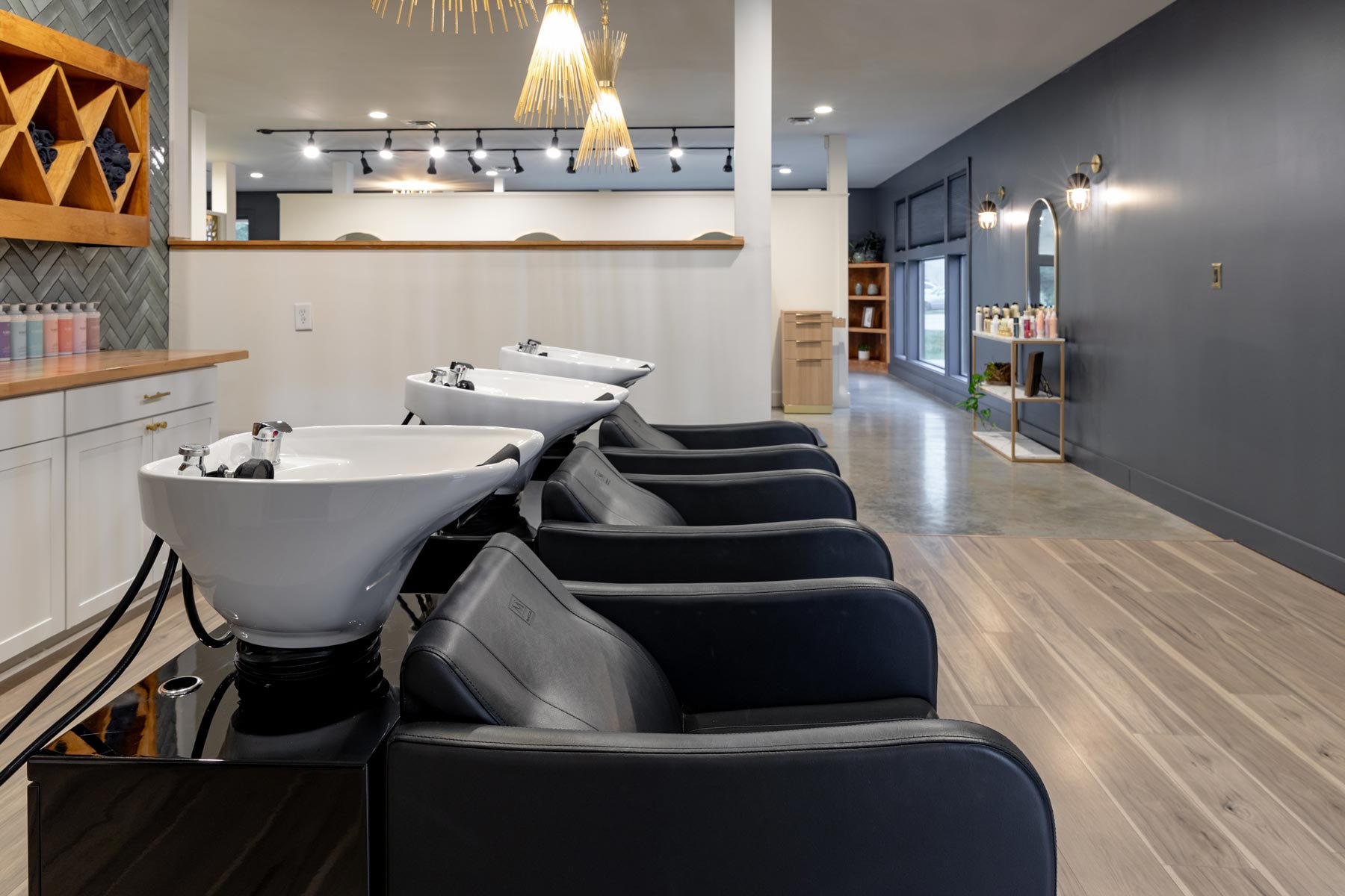 Vibe Salon interior view of shampoo area with three shampoo systems and color bar