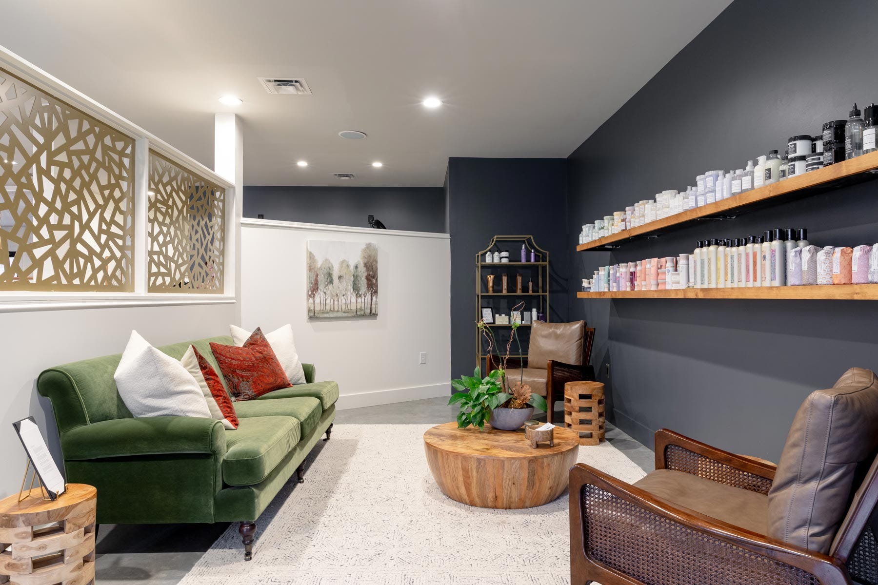 Vibe Salon interior view of waiting area with sofa, chair and product shelving