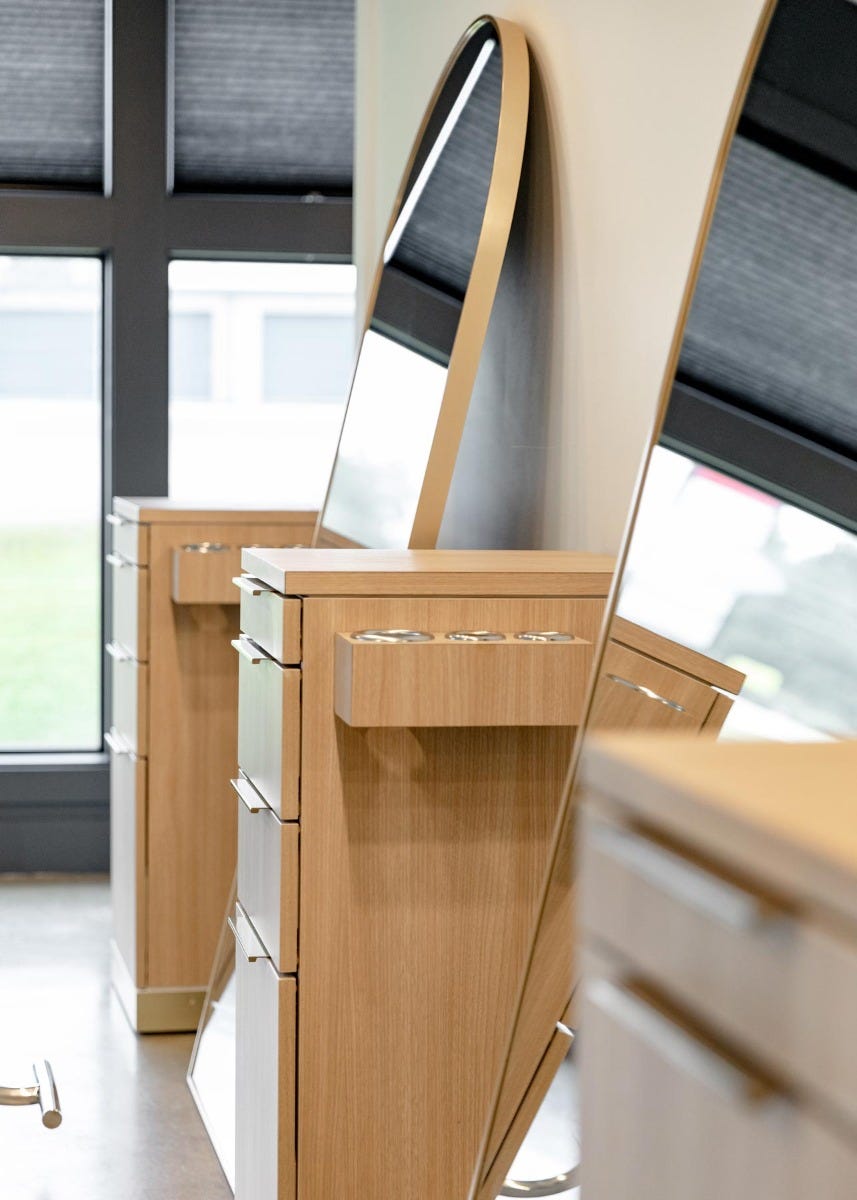 side view of salon styling stations with tool holders on the side and a full length mirror in between each station